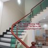 Cầu thang kính cường lực chân inox tay vịn gỗ lim